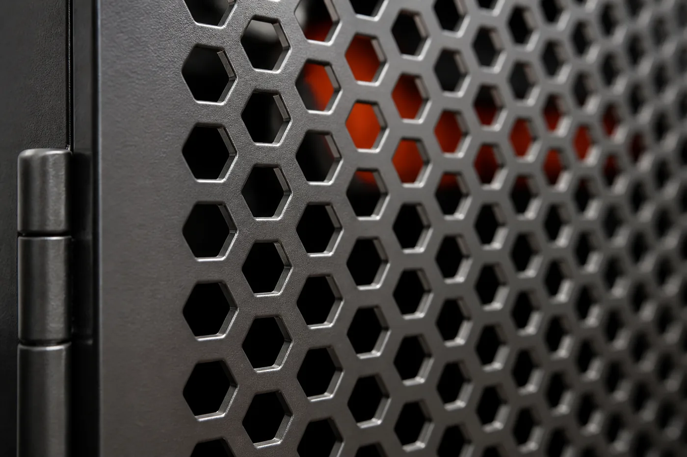 Laser-cut sheet metal panel with a hexagonal perforation pattern showing the cut edge thickness